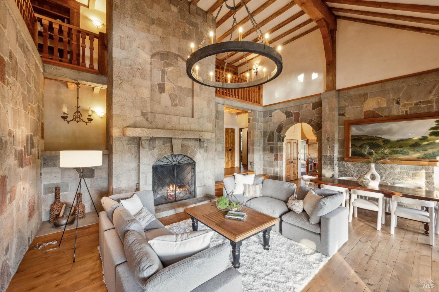 The great room with a lit stone fireplace